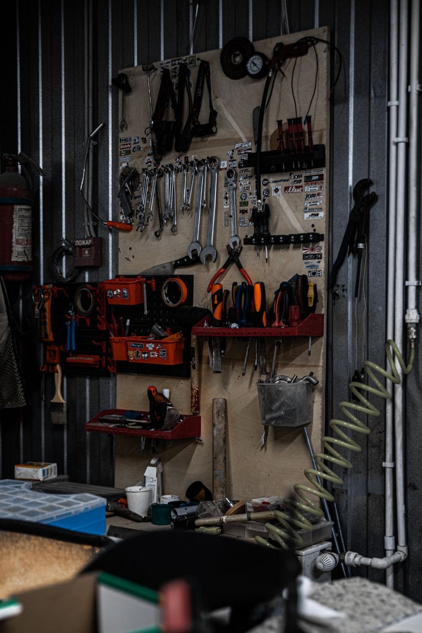 A wall of organized wrenches and plumbing hand tools in a well-equipped workshop